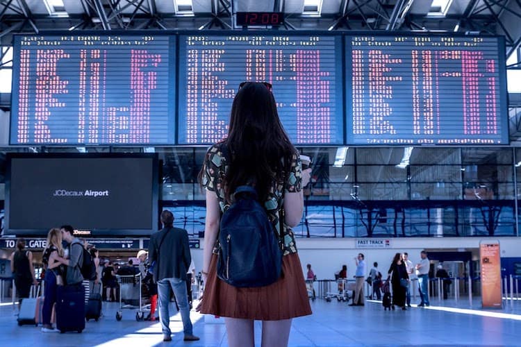 A lady staring at airport departures boards